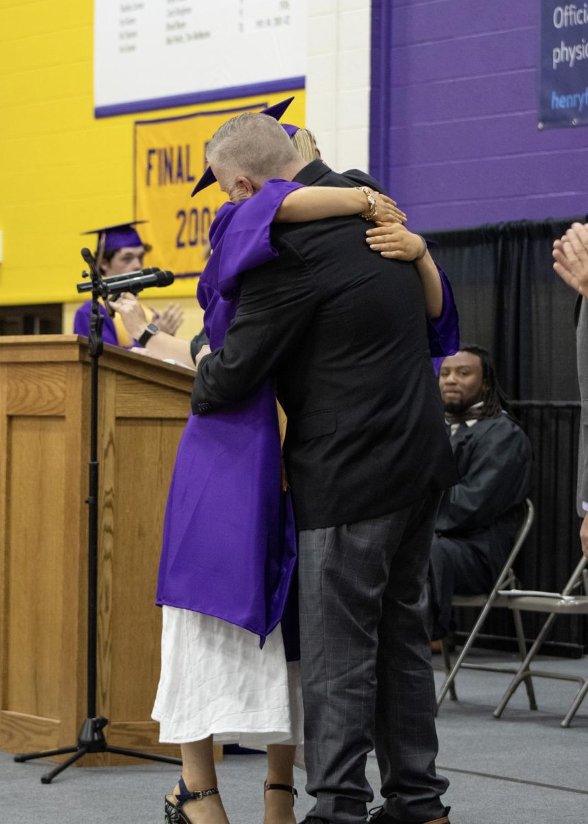 Riley Adams giving a hug to her dad after receiving her diploma.