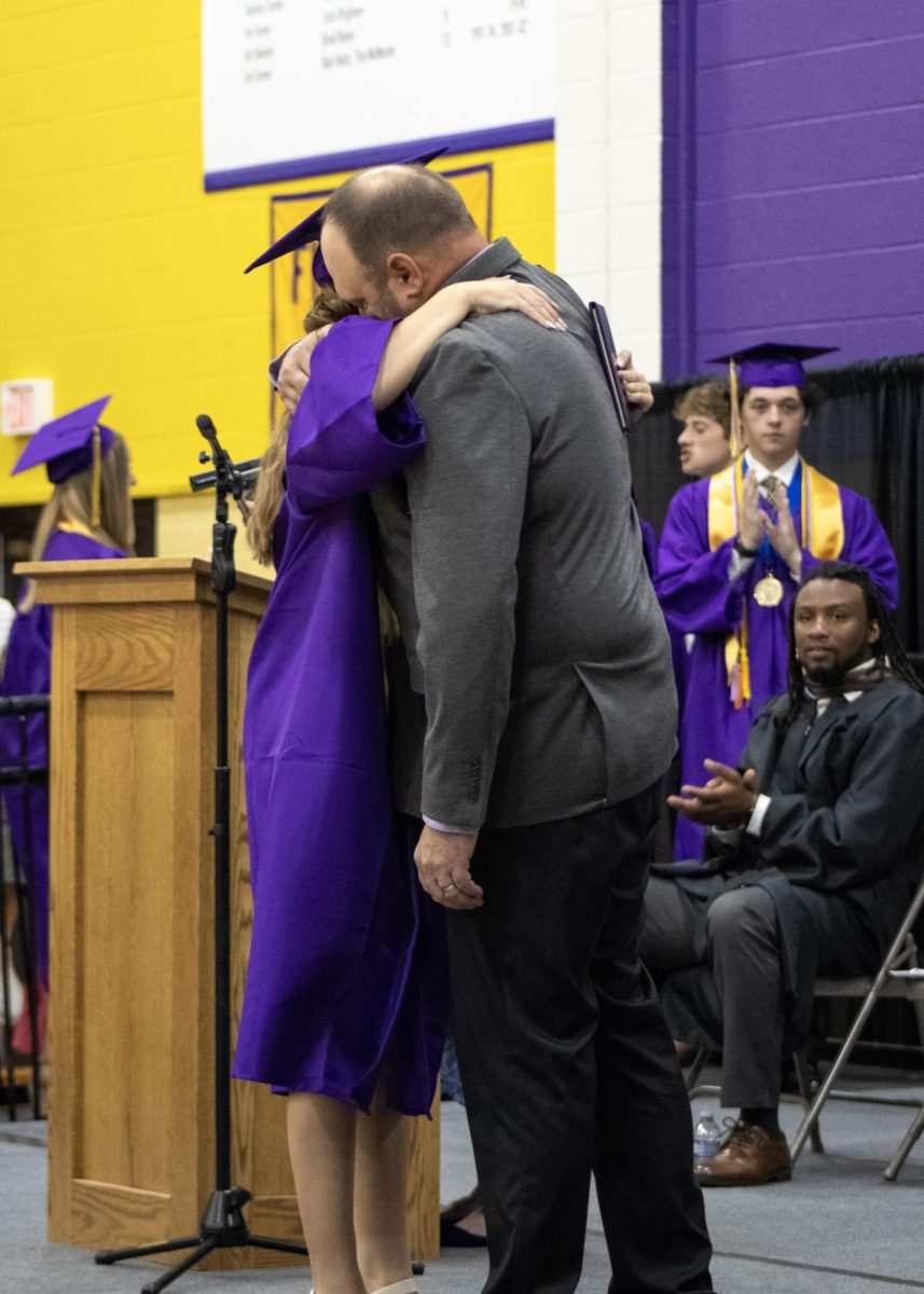 Rylee Sinden giving a hug to her dad after receiving her diploma.
