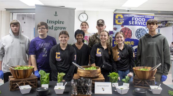 The group of students in hydroponics posing around the lettuce and dill they grew.