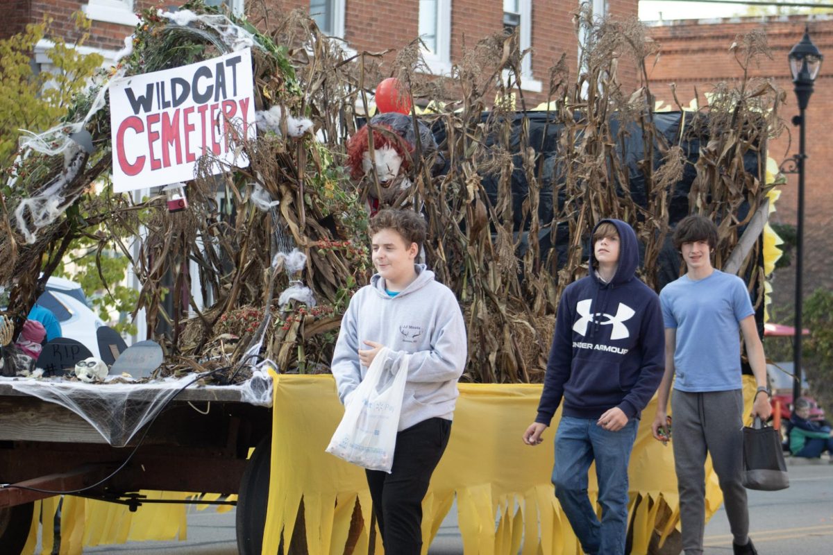 Three freshman walking with the 1st place winning freshman float.