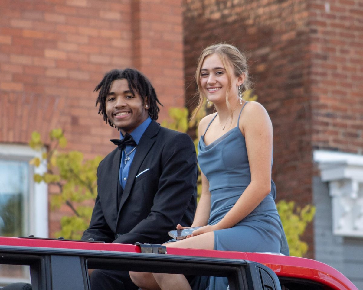 Past Homecoming representatives Tyzjohn Allen, and Rylee Sinden driving through the parade