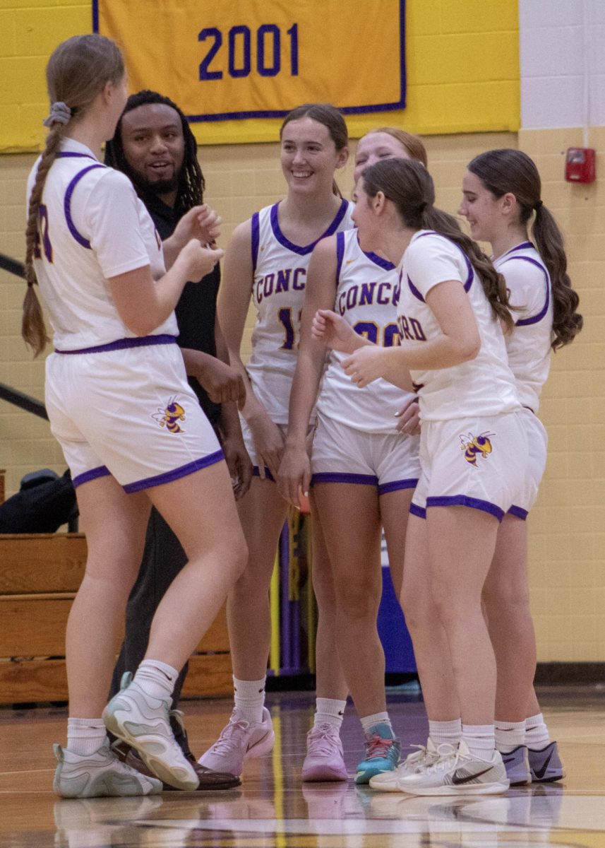 The Varsity Jackets share a moment of laughter with their coach Arshawn Parker prior to Monday's game. 