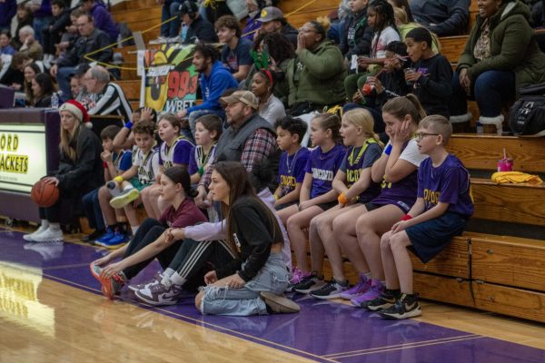 Young athletes cheer on their classmates waiting to play