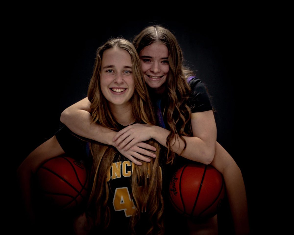 Grace Thorrez and Hannah Stimer taking photos for basktball 