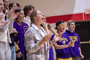 Grace cheering for the team during a volleyball game.