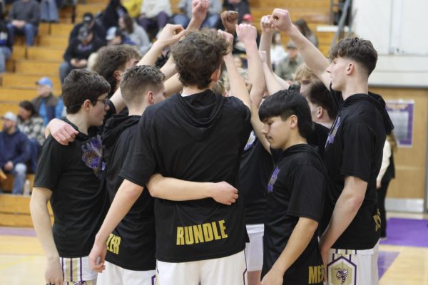 The boys getting together to hype each other up before the game. 