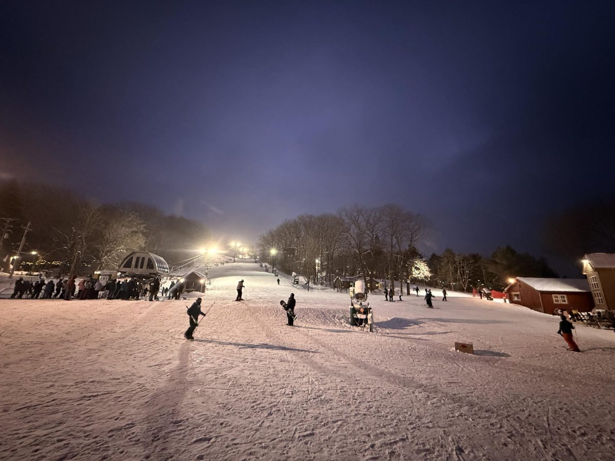 People skiing  and snowboarding at night