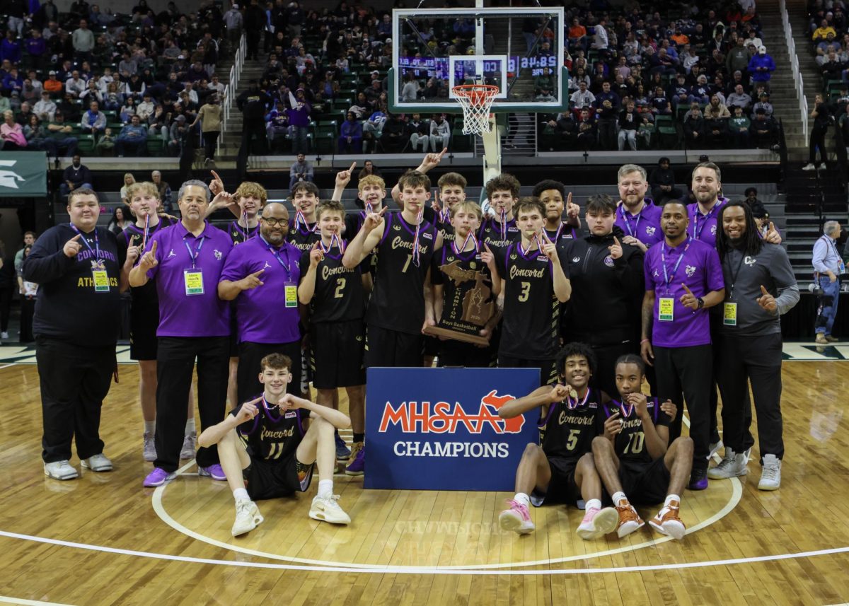 The team celebrating with the trophy on the floor of the Breslin.